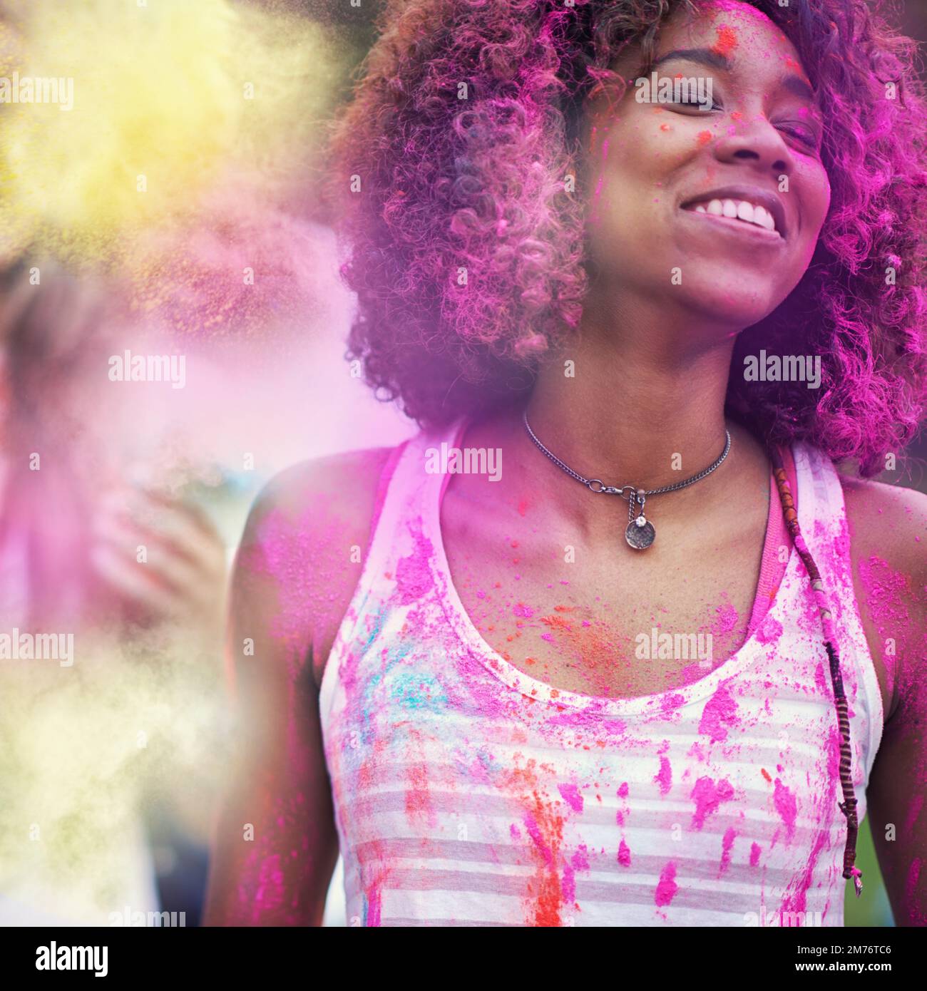 Laisser ses vraies couleurs briller. une jeune femme attrayante couverte de poudre de peinture pourpre en plein air lors d'un festival de couleurs. Banque D'Images