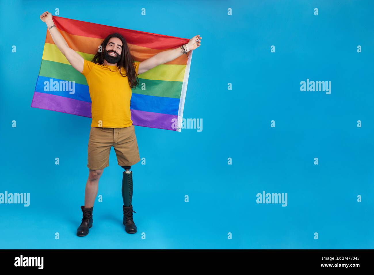 Homme heureux avec une jambe prothétique agitant un drapeau lgbt Banque D'Images