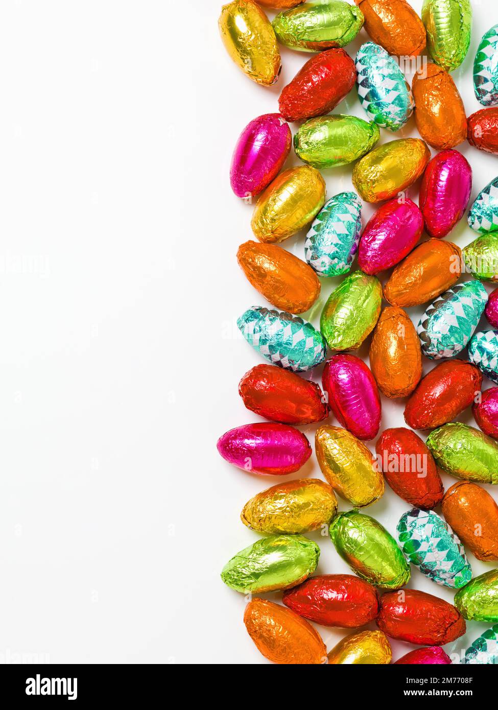 C'est ce à quoi cela ressemblerait si la pluie était du chocolat. Photo en studio d'un tableau éblouissant d'œufs de pâques multicolores enveloppés de papier d'aluminium. Banque D'Images