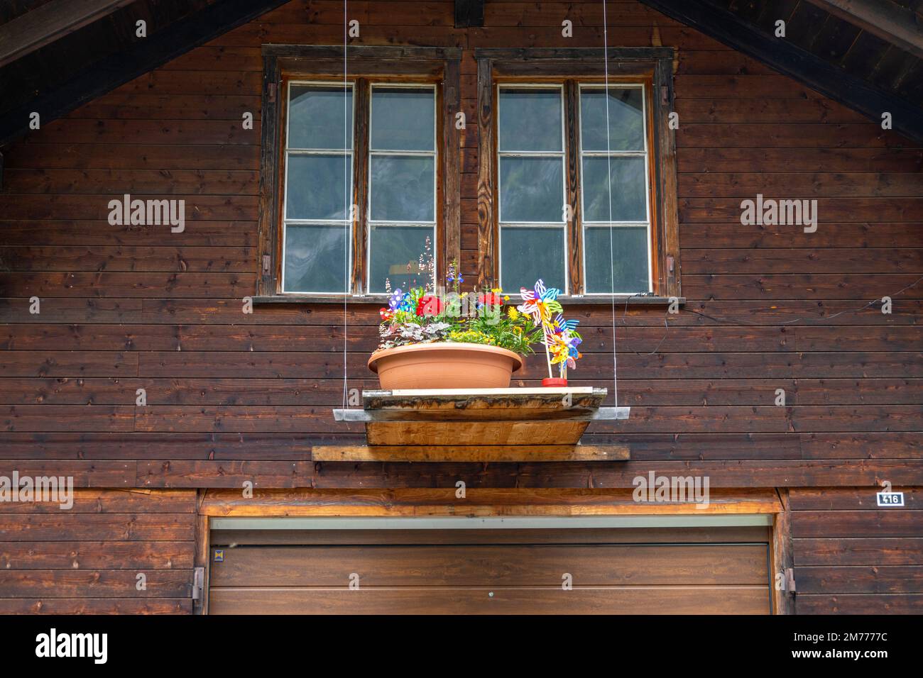 Pot de fleurs sur un seuil de fenêtre avec façade en bois Banque D'Images