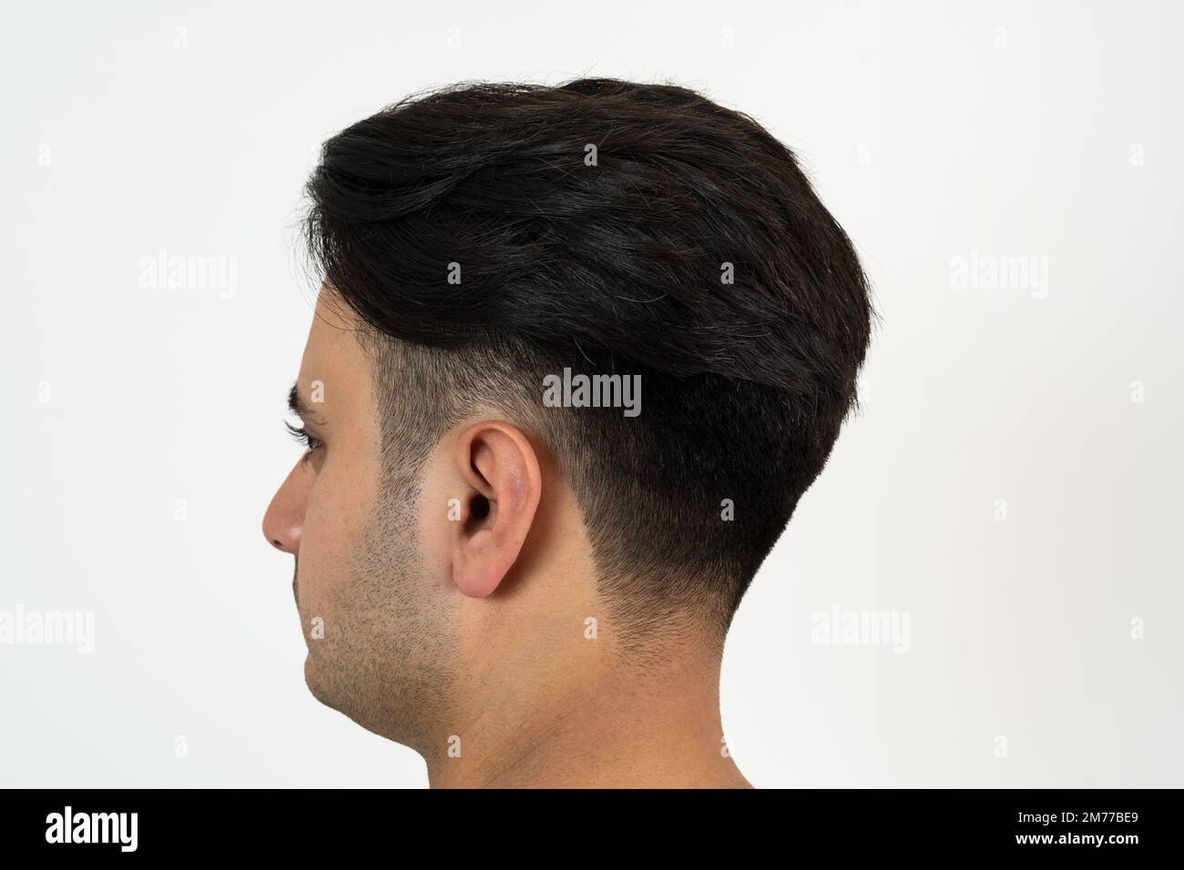 Portrait d'un homme à la peau brune avec des cheveux noirs soyeux bien entretenus sur un fond blanc isolé. Banque D'Images