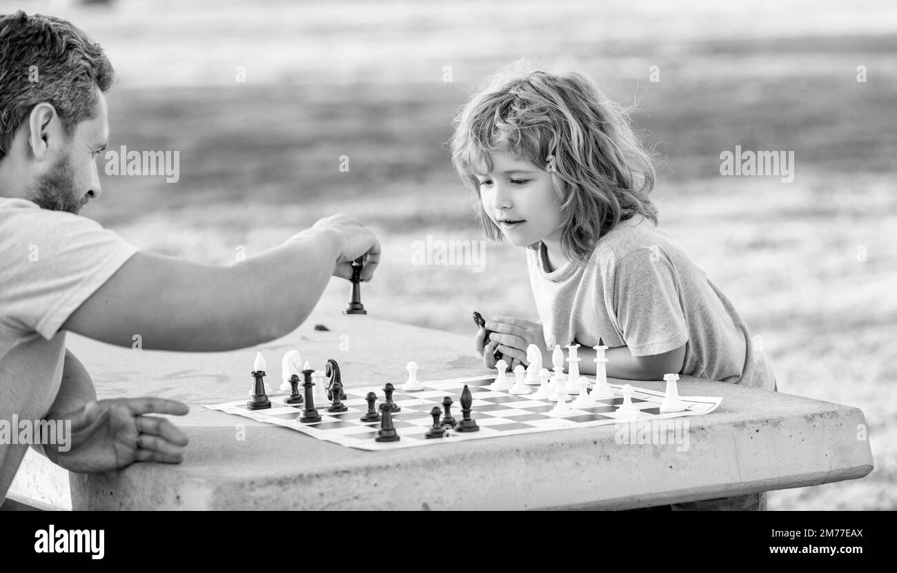 stratégique et tactique. tutelle. papa et gamin jouent à la logique. père et fils jouant aux échecs à l'extérieur Banque D'Images