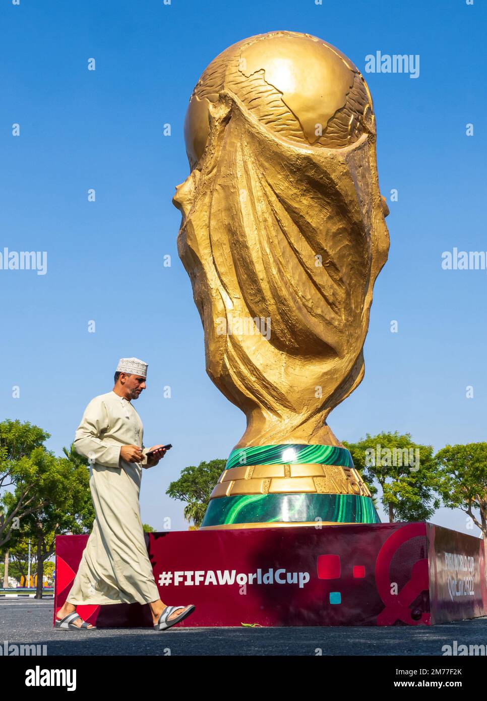 Doha, Qatar. 08th janvier 2023. Un homme passe devant un grand trophée de la coupe du monde de la FIFA qui se tient devant le stade Khalifa dans la ville désertique. Le FC Bayern Munich termine son camp d'entraînement d'hiver à Doha (Qatar) jusqu'en 12.01.2023. Crédit : Peter Kneffel/dpa - REMARQUE IMPORTANTE : Conformément aux exigences de la DFL Deutsche Fußball Liga et de la DFB Deutscher Fußball-Bund, il est interdit d'utiliser ou d'avoir utilisé des photos prises dans le stade et/ou du match sous forme de séquences et/ou de séries de photos de type vidéo./dpa/Alay Live News Banque D'Images