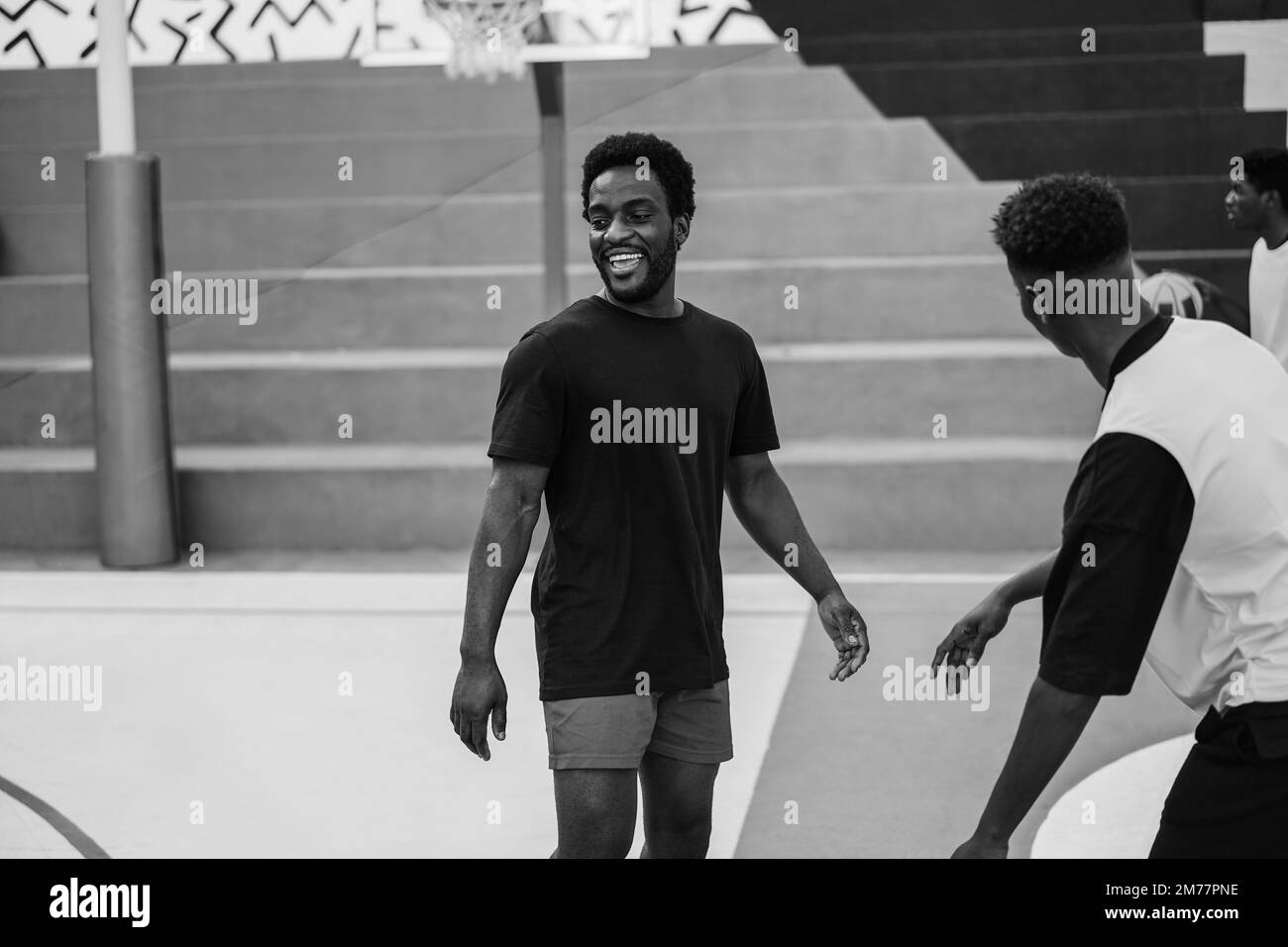 Amis africains jouant au basket-ball en extérieur - Focus sur. Centrer le visage de l'homme - montage en noir et blanc Banque D'Images