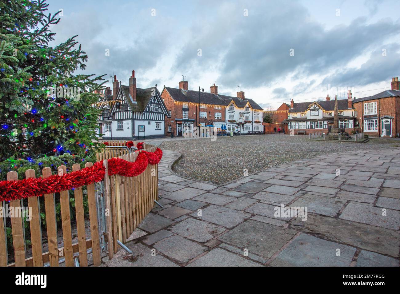 La place pavée du marché à Sandbach à Cheshire avec son arbre de Noël et ses lumières l et noir et blanc entraîneur inn Banque D'Images