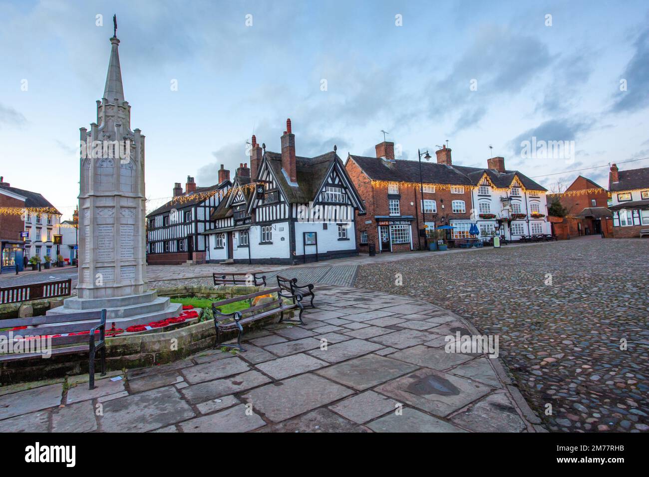 La place du marché pavée de la ville de Sandbach à Cheshire avec son monument commémoratif de guerre au cénotaphe et son auberge de coaching noir et blanc Banque D'Images