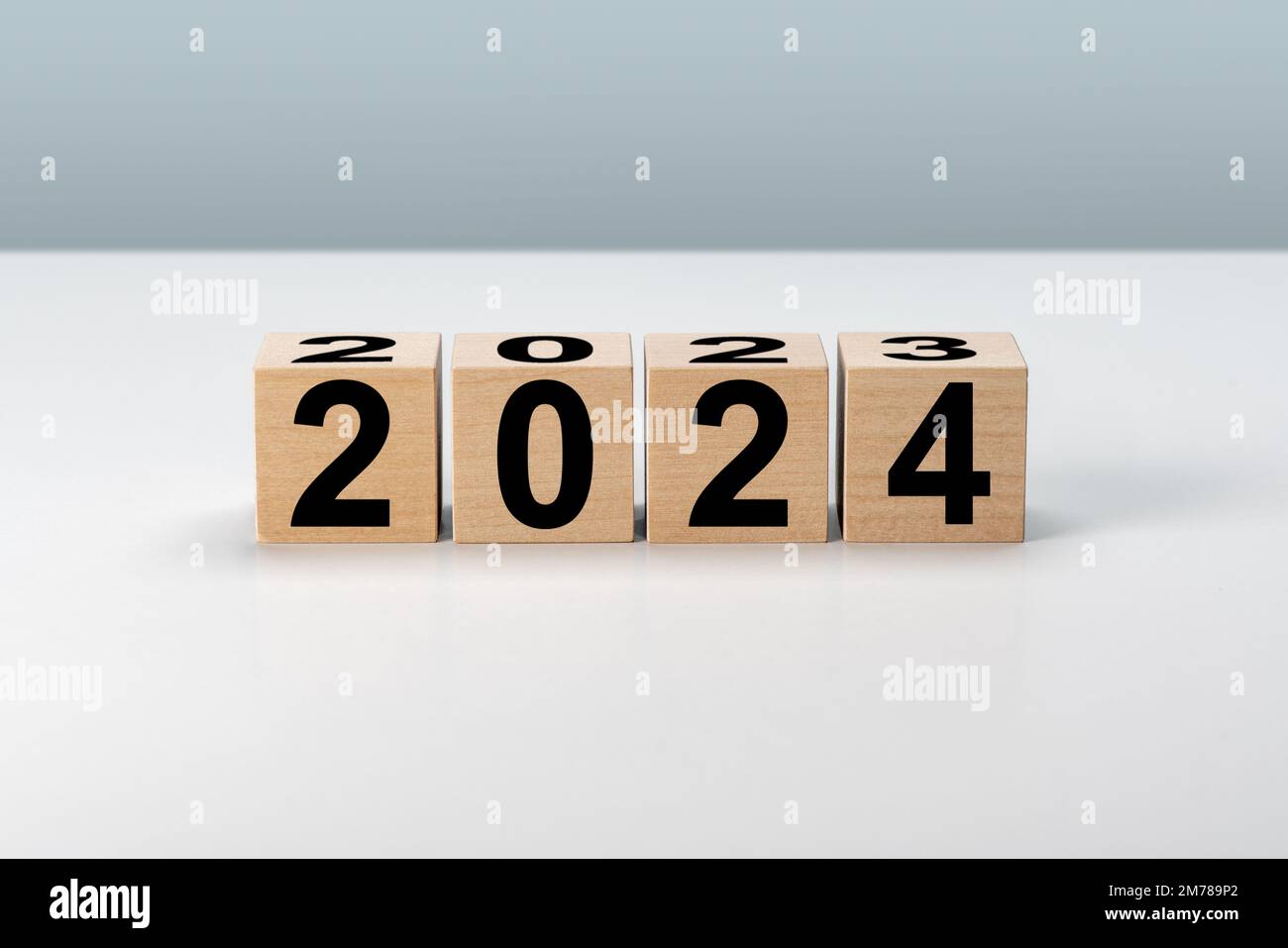 Nouvelle année 2024. Blocs de bois 2024 sur fond gris neutre. 2023 à 2024 sur un cube en bois pour la préparation du changement de nouvelle année et pour commencer de nouvelles affaires Banque D'Images