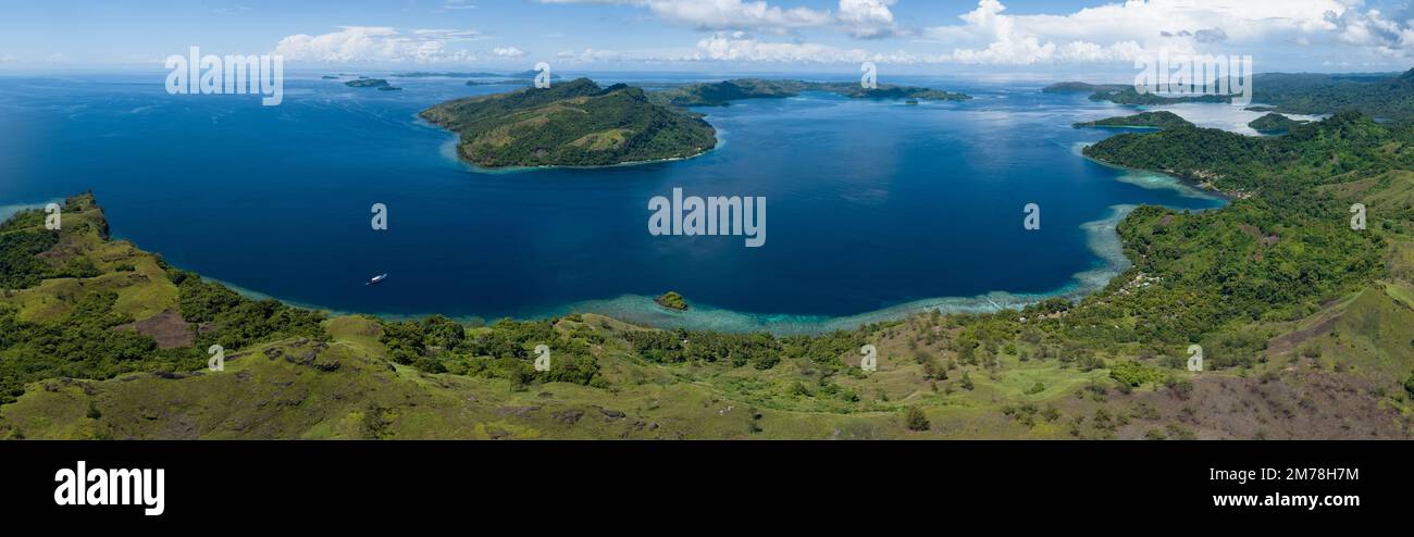 Une île tropicale pittoresque est bordée d'un récif de corail sain dans les îles Salomon. Ce beau pays abrite une biodiversité marine spectaculaire. Banque D'Images