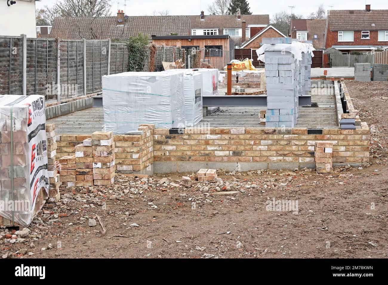 Emballage plastique enveloppant sur blocs isolants et briques de face matériaux de construction pour la construction de nouvelles maisons individuelles sur terrain infill UK Banque D'Images