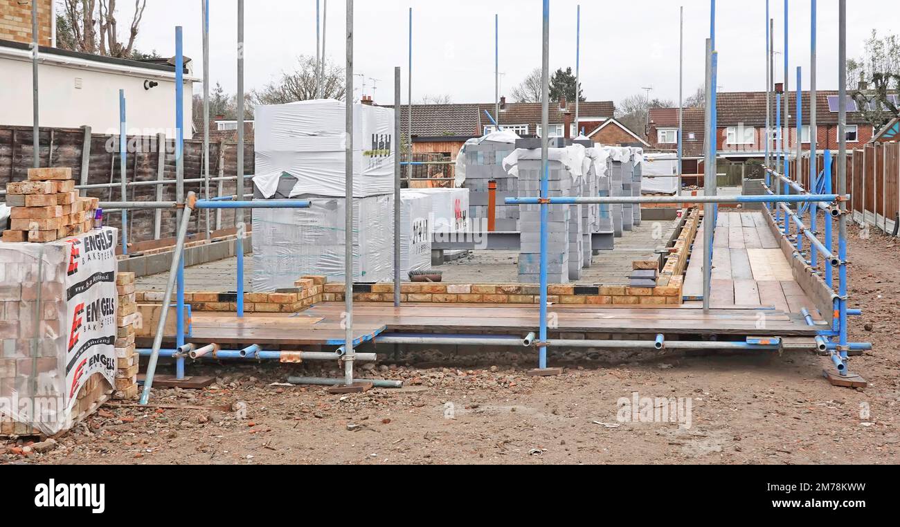 Un entrepreneur spécialisé en échafaudage commence la construction d'une plate-forme de travail sécurisée pour les briques de construction de maisons et autres ouvriers anglais Banque D'Images