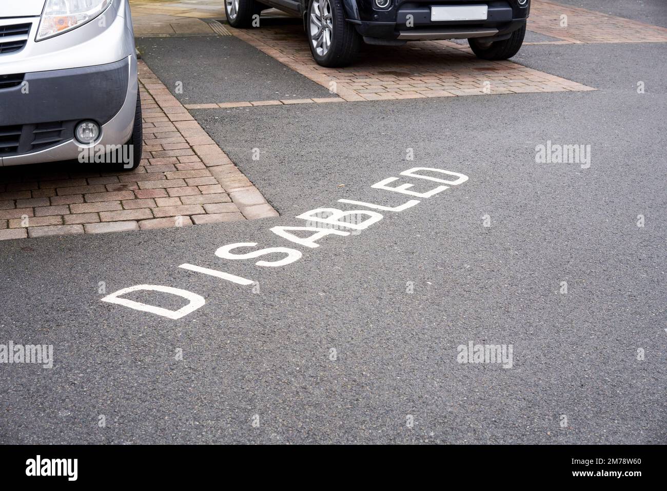 Parkings handicapés avec le mot Disabled peint en blanc sur la surface en asphalte du tarmac Banque D'Images