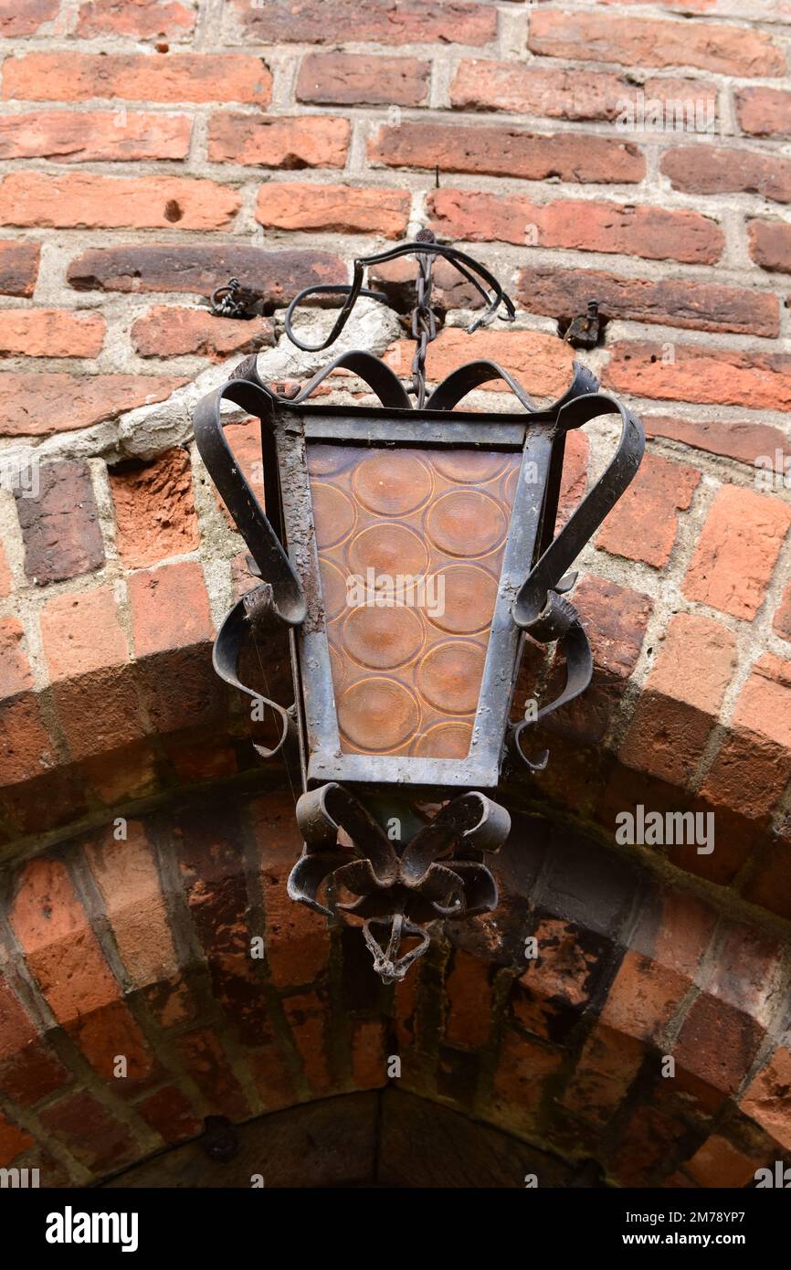 Entrée dans un bâtiment historique en briques avec une lanterne suspendue au-dessus de la porte. Mur. Banque D'Images