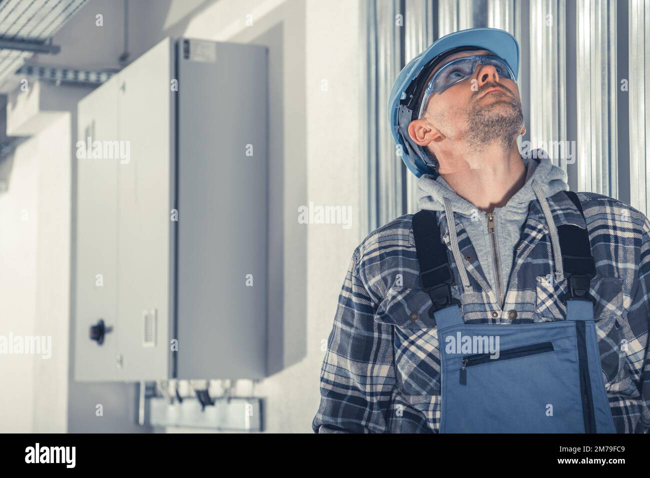 Technicien professionnel regardant les conduits HVAC installés sous le plafond dans le bâtiment commercial. Système de chauffage, climatisation et ventilation Banque D'Images