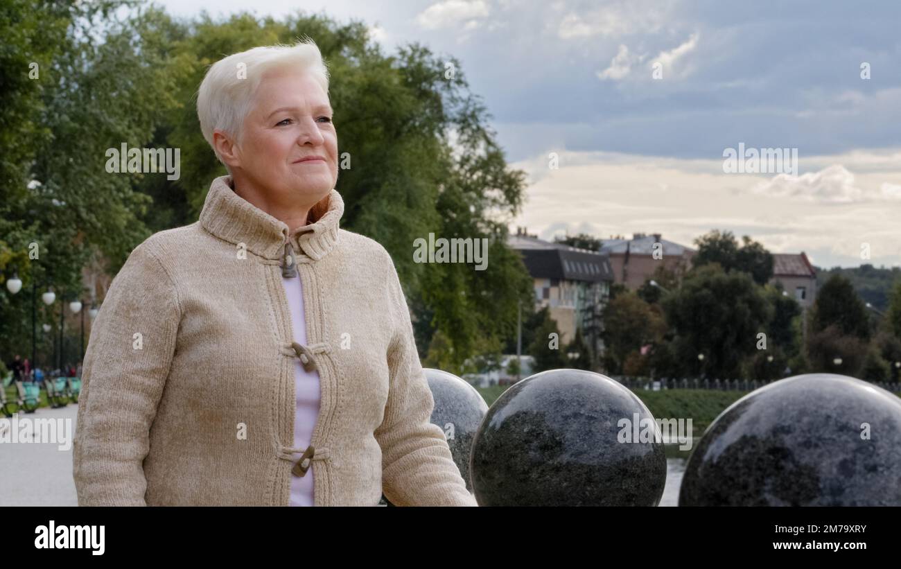 Gros plan triste sérieux attrayant 65s femme en âge de retraite. Calme couvant femme mûre dans des vêtements décontractés avec gris élégant cheveux courts style coiffure Banque D'Images