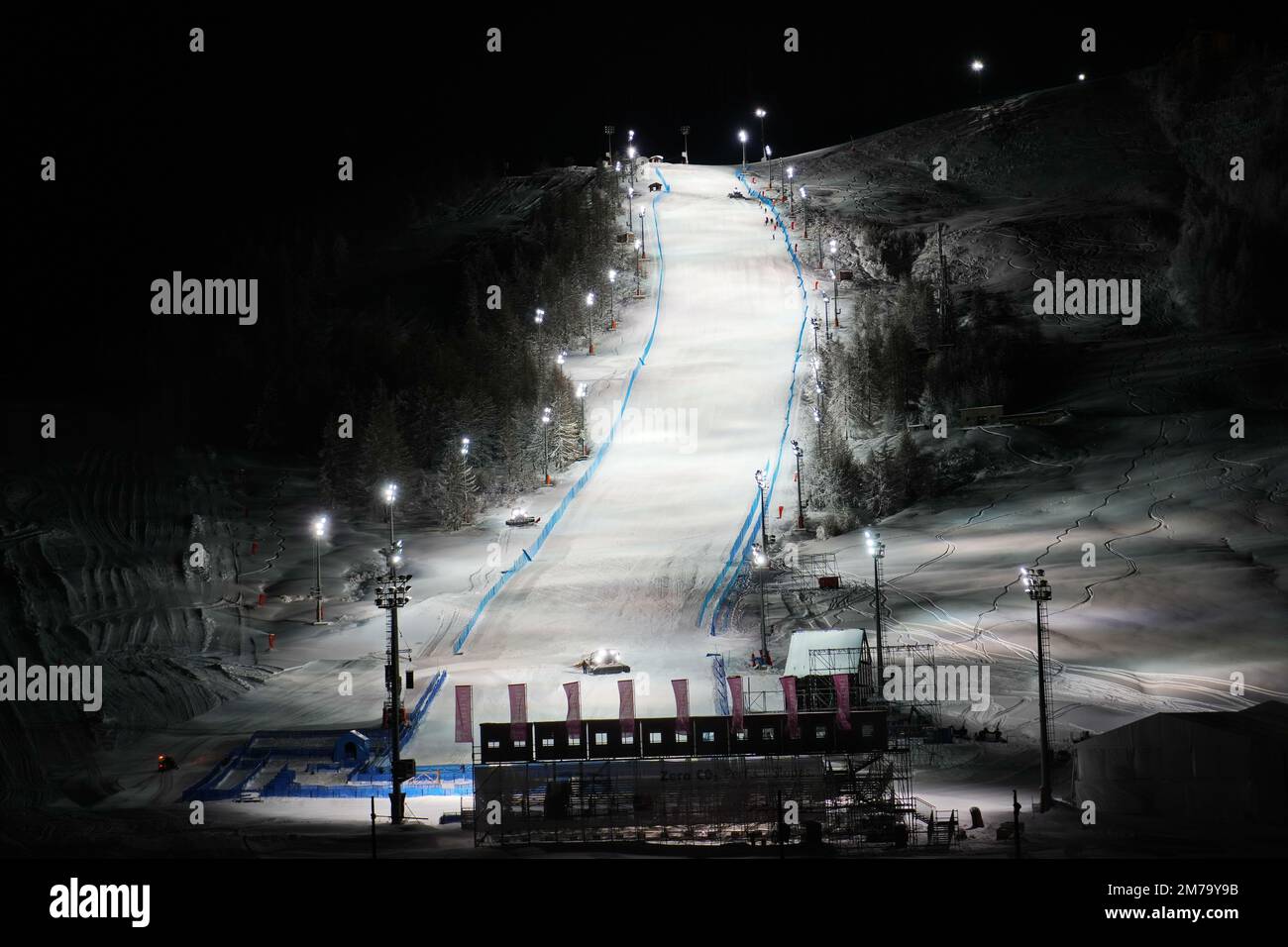 Vue panoramique nocturne sur une piste de ski enneigée éclairée. Service de ski de nuit à la station de montagne d'hiver de Sestriere Banque D'Images