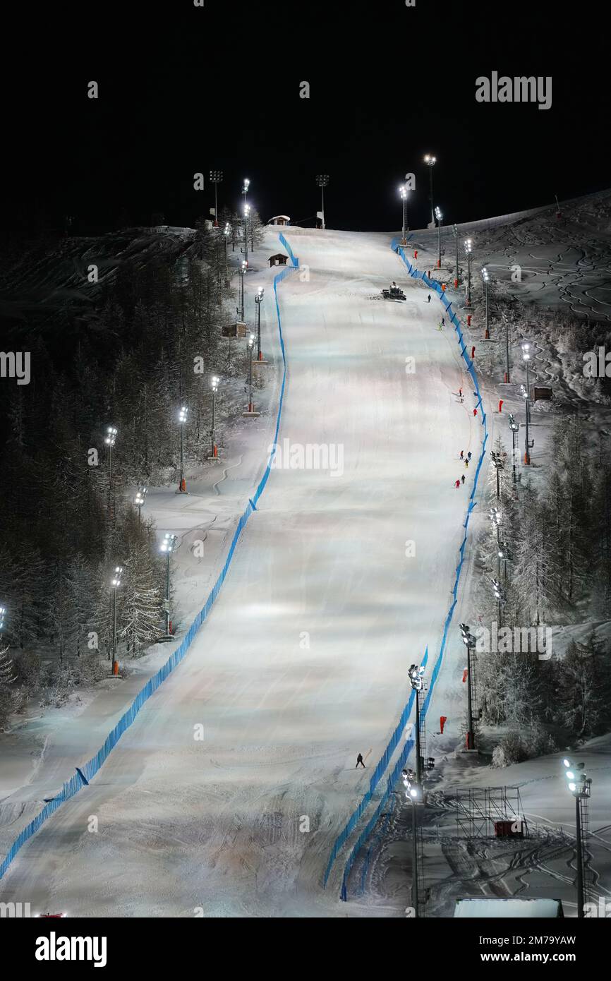 Vue panoramique nocturne sur une piste de ski enneigée éclairée. Service de ski de nuit à la station de montagne d'hiver de Sestriere Banque D'Images