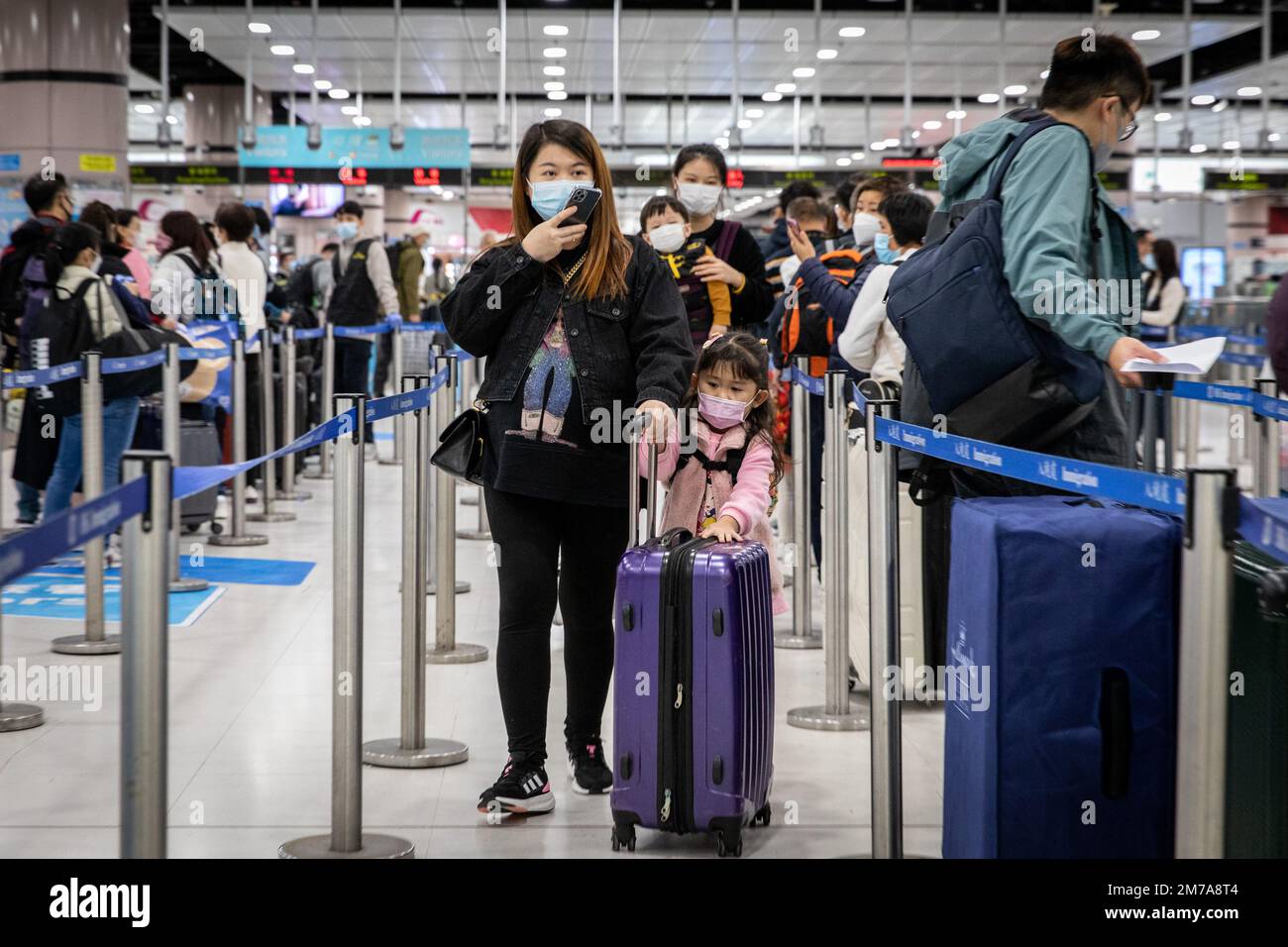 Hong Kong, Hong Kong. 08th janvier 2023. Les parents et leurs enfants ont marché jusqu'à la file d'attente au contrôle des frontières au départ de Shenzhen, en Chine, à Lok Ma Chau. Le port de Futian/le point de contrôle de la ligne d'épi Lok Ma Chau et la station Lok Ma Chau reliant Shenzhen, en Chine, ont repris leur service transfrontalier et ont accueilli le premier lot de passagers transfrontaliers pour la première fois en trois ans après la pandémie de COVID-19, le matin de 8 janvier, Dans le cadre de la reprise du contrôle normalisé des frontières entre la Chine et Hong Kong. Crédit : SOPA Images Limited/Alamy Live News Banque D'Images