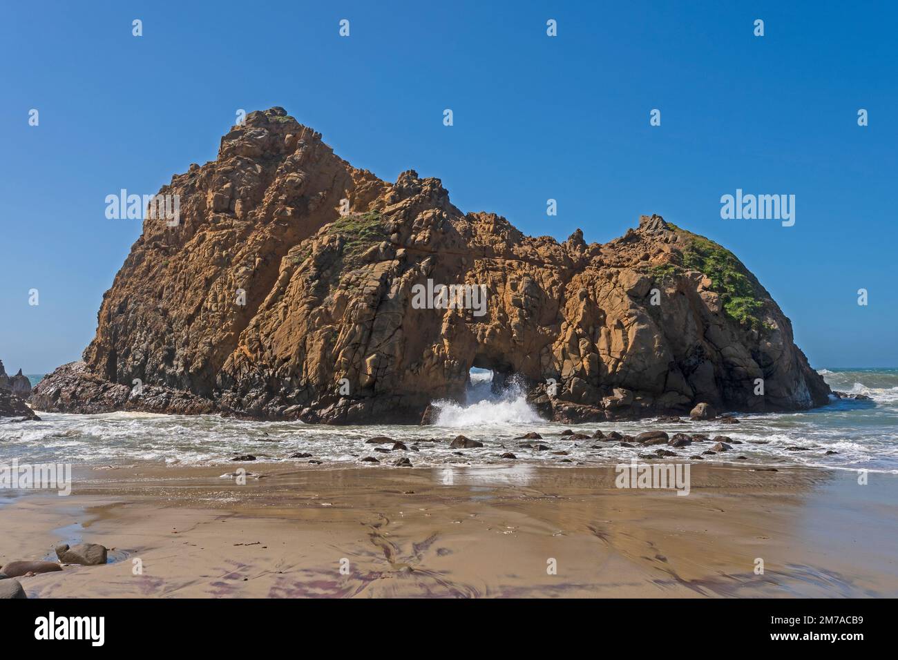 L'eau s'écrasant à travers une arche de mer à Pfeiffer Beach en Californie Banque D'Images