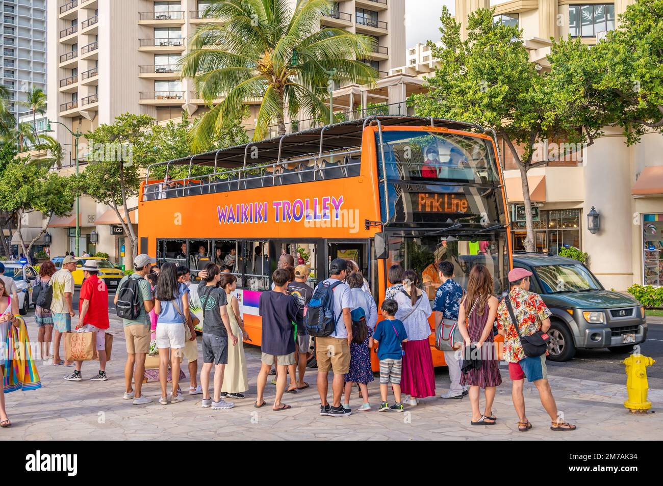 Honolulu, Hawaï - 29 décembre 2022 : le tramway de Waikiki qui prend les touristes sur l'avenue Kalakaua. Banque D'Images