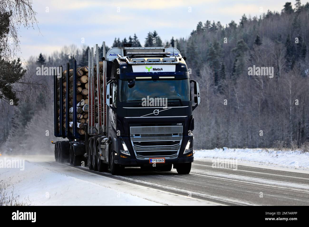 Le nouveau camion de transport Å Björkqvist, Volvo FH16 noir, transporte la charge de grumes le long de l'autoroute en hiver. Salo, Finlande. 27 décembre 2021. Banque D'Images