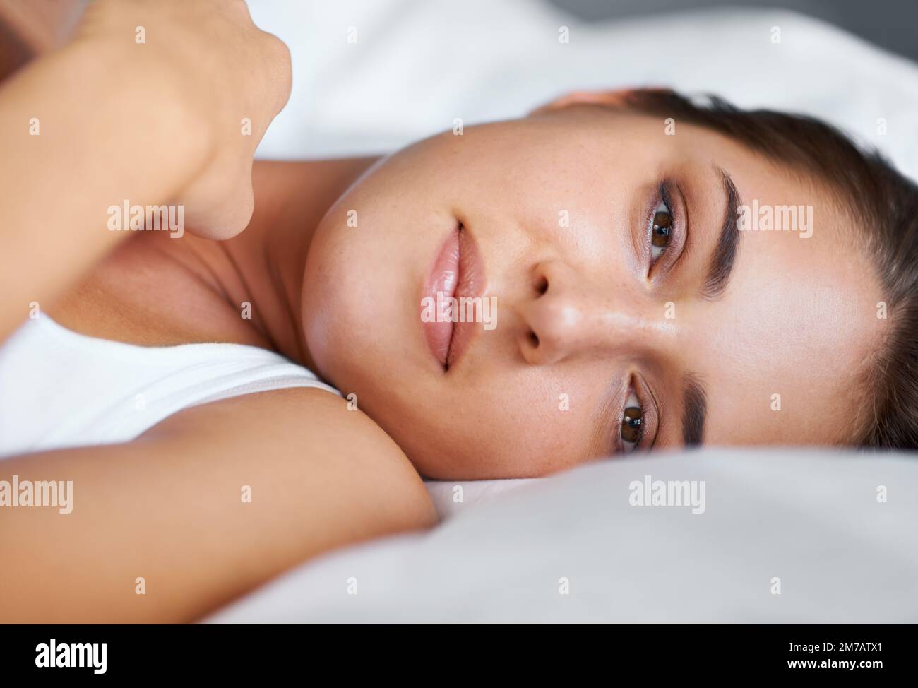 Beauté au lit. Portrait d'une jeune femme couché sur le côté dans le lit. Banque D'Images