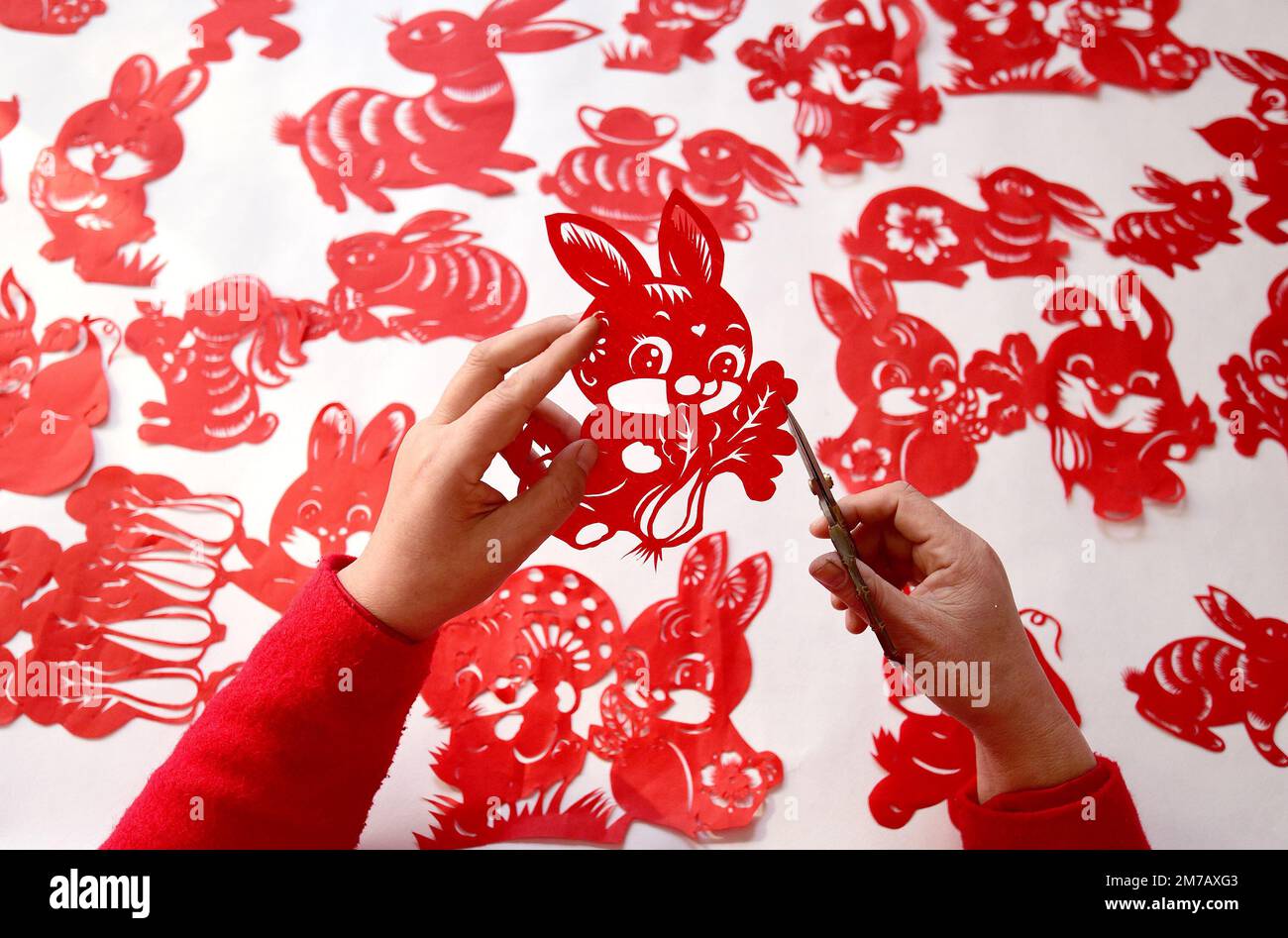 HANDAN, CHINE - le 9 JANVIER 2023 - Feng Shiping, artiste de la coupe de papier folklorique, crée des coupes de papier pour l'année du lapin dans la ville de Handan, dans le Hebei en Chine du Nord Banque D'Images
