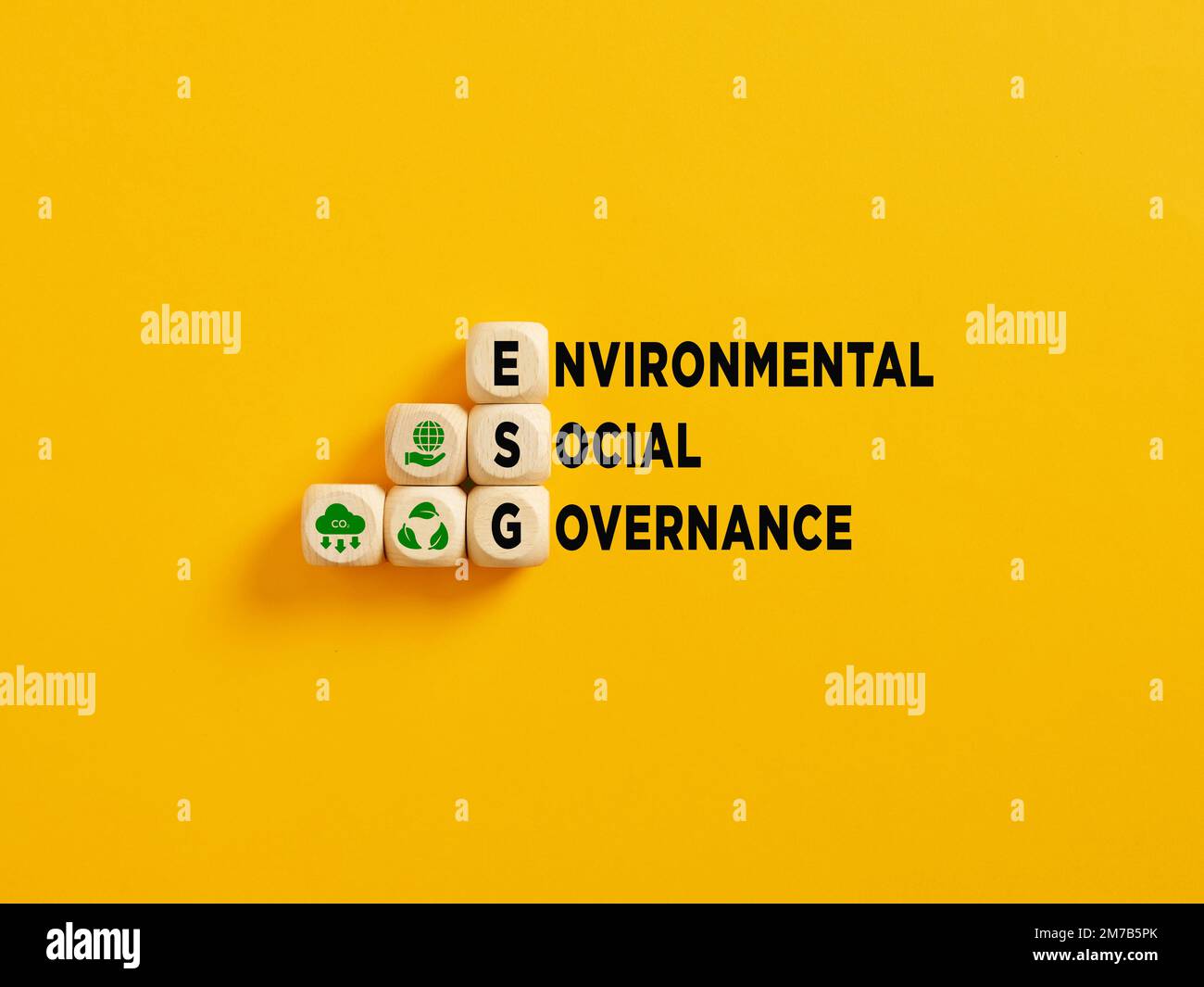 L'acronyme ESG et Environmental social Governance text sur cubes en bois sur fond jaune. Banque D'Images