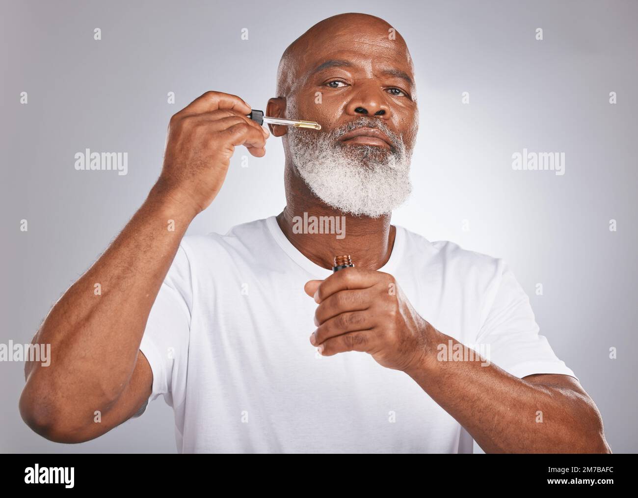 Homme âgé, sérum pour le visage et soins de la peau avec dermatologie et cosmétiques pour une peau propre, lumineuse et fraîche. Portrait d'un homme noir avec une pipette pour Banque D'Images
