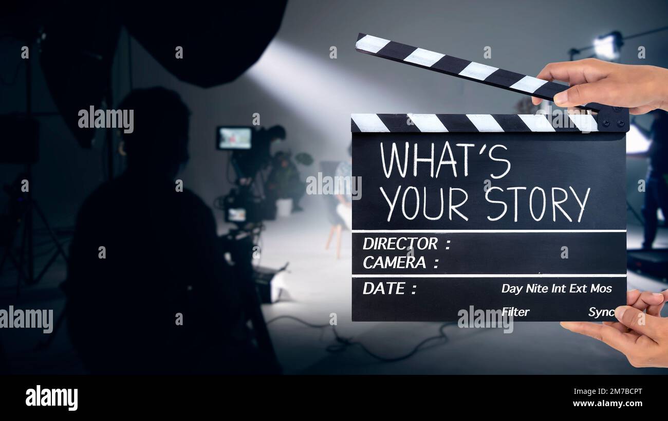 Quelle est votre histoire, écriture manuscrite sur ardoise de film ou clapperboard. Équipe de film travaillant dans le studio. Banque D'Images