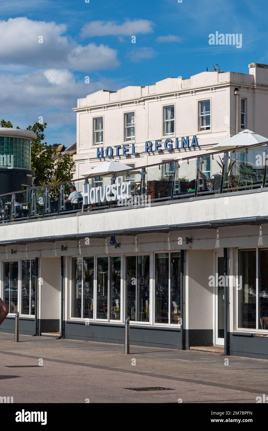 Vue sur l'avant de l'hôtel Regina, Victoria Parade, Torquay, Devon, Royaume-Uni. Au premier plan se trouve un restaurant Harvester. Banque D'Images