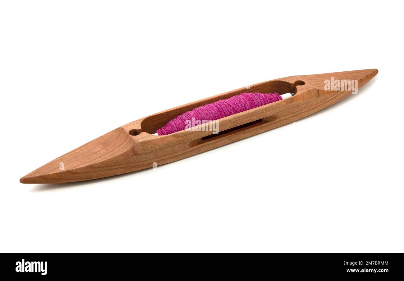 Navette de bateau isolée avec fil rose ou magenta utilisé dans le tissage de métier à tisser. Navette en bois sur fond blanc Banque D'Images