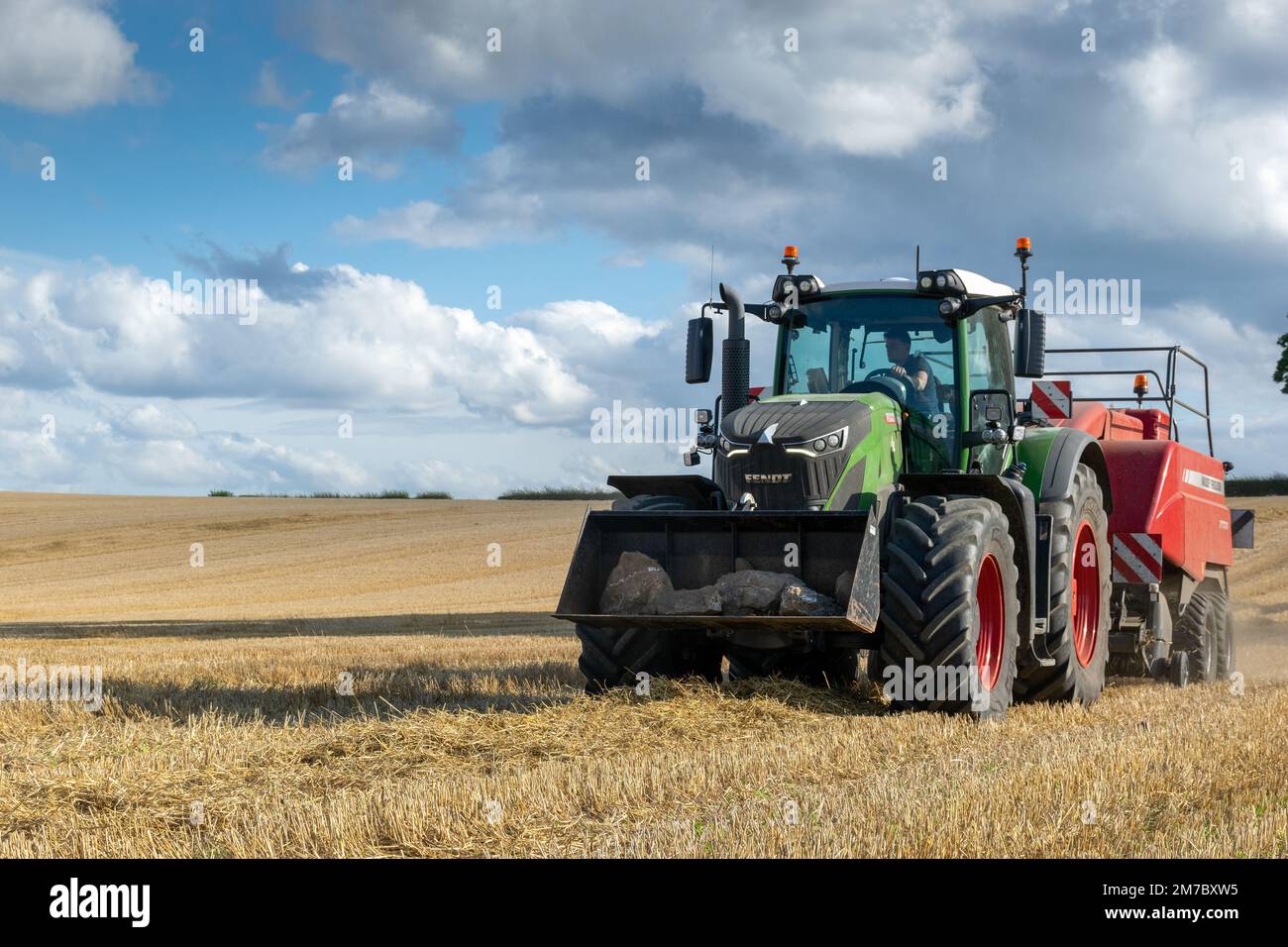 Agriculteur qui a mis en balles de grosses balles de paille avec une presse à balles Massey Ferguson 2170XD et un tracteur Fendt, North Yorkshire, Royaume-Uni. Banque D'Images