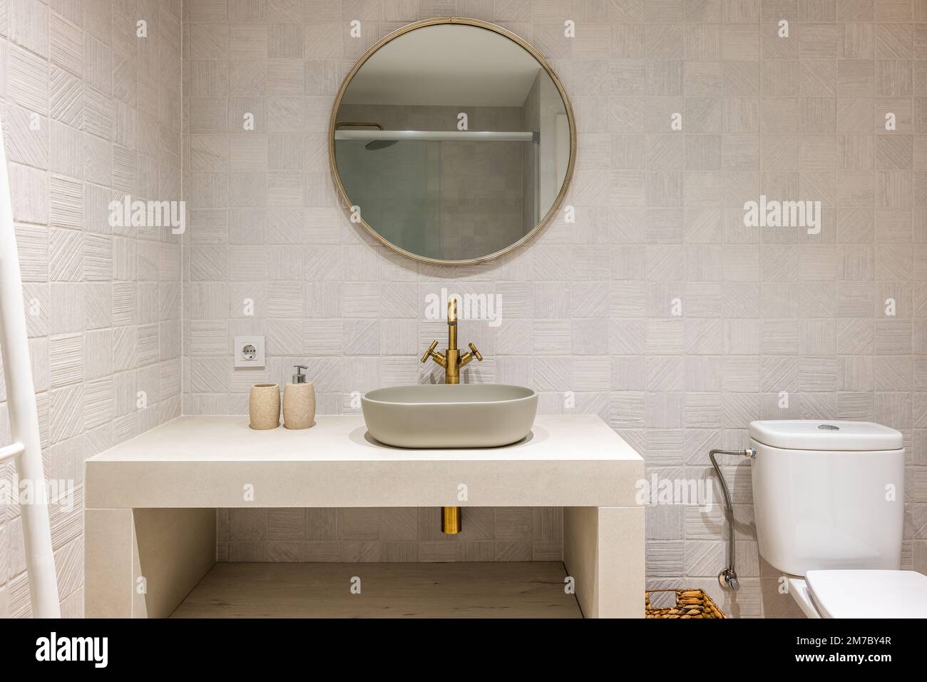 Salle de bain magnifiquement conçue et lumineuse, tons pastel, touches de cuivre et de métal. Douche avec cloison en verre Banque D'Images