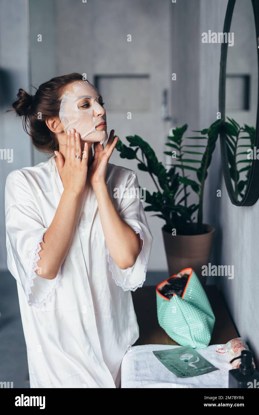 Femme fait des soins de rajeunissement du visage à la maison. Banque D'Images