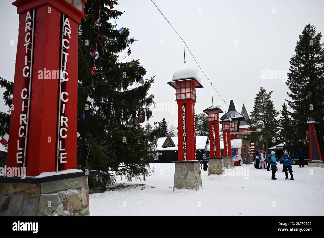Dans le village du Père Noël, à quelques kilomètres au nord de Rovaniemi, la ligne symbolique du cercle arctique est représentée par cet alignement des poteaux rouges. Banque D'Images