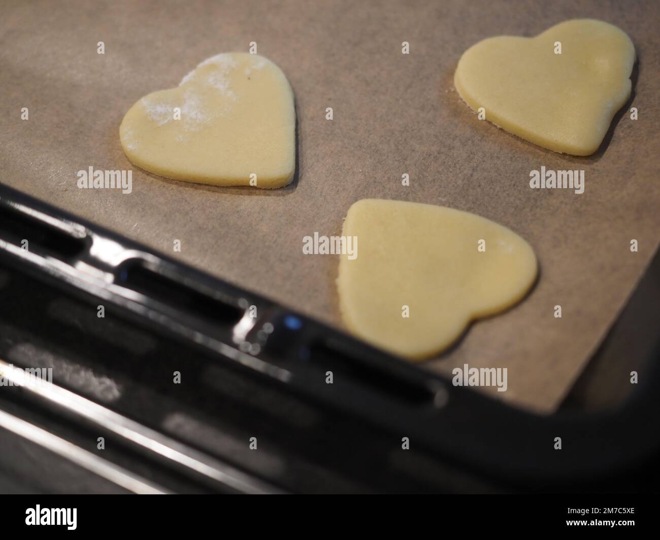 Biscuits faits maison en forme de coeur sur une plaque de cuisson Banque D'Images