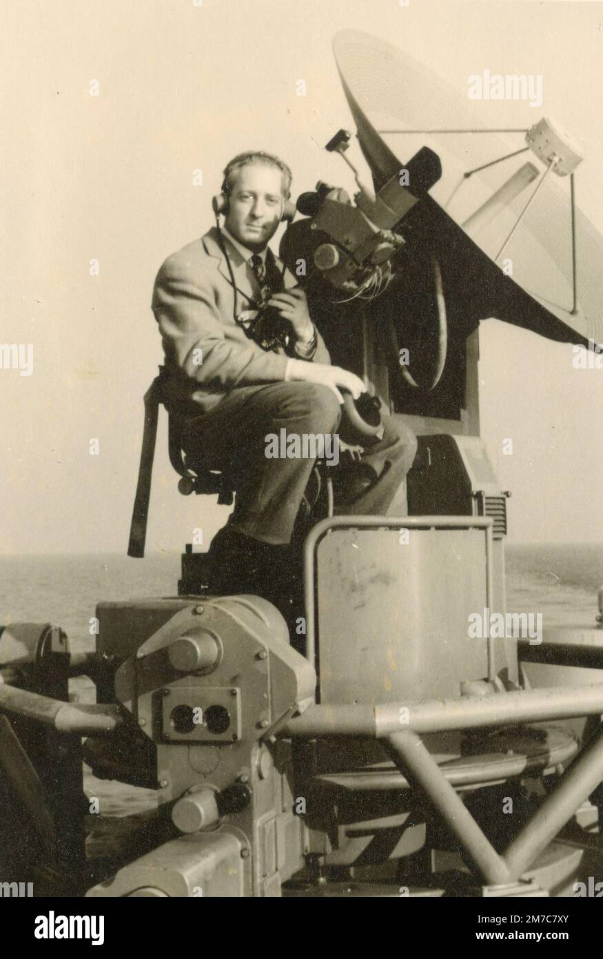 Homme à bord d'un navire de la Marine italienne manouvrant une antenne parabolique, Italie 1958 Banque D'Images
