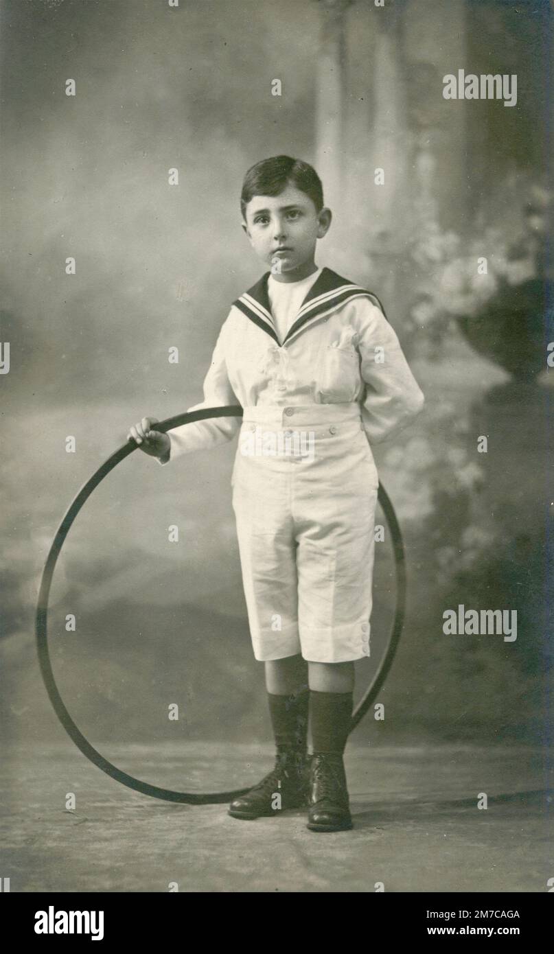 Jeune garçon habillé style marin avec le jeu de hula Hoop, Italie 1920s Banque D'Images