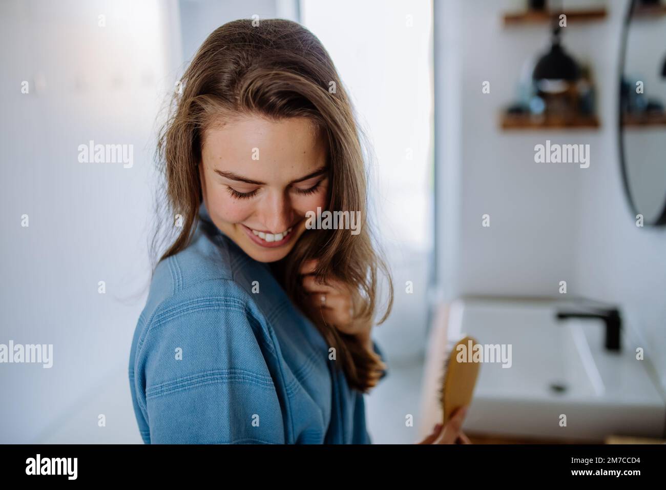 Jeune femme prenant soin de ses cheveux, concept de routine de beauté du matin. Banque D'Images
