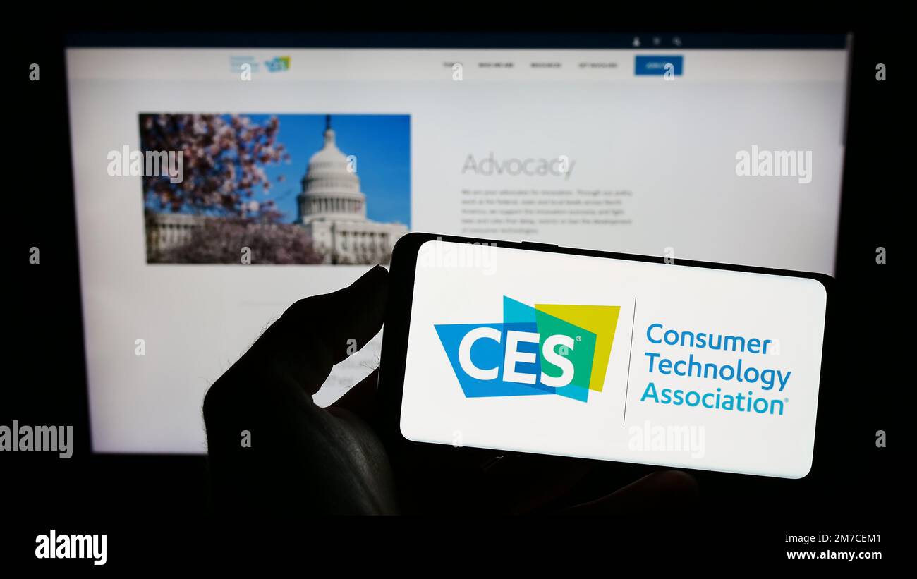 Personne tenant un téléphone portable avec le logo de l'American Consumer Technology Association (CTA) à l'écran devant le site Web. Mise au point sur l'affichage du téléphone. Banque D'Images