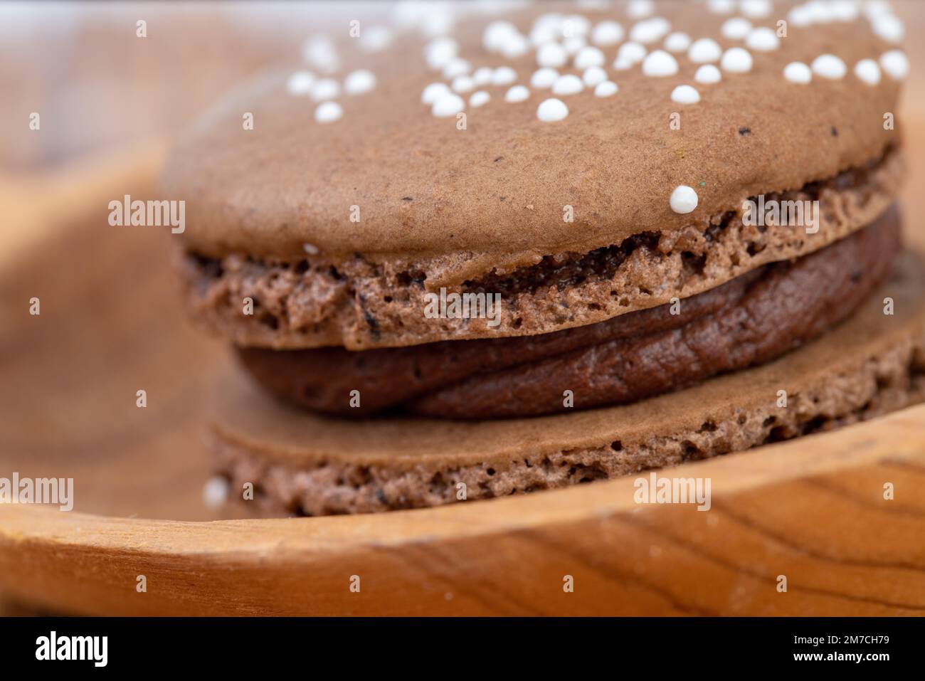 Le chocolat macron servi sur une cuillère en bois Banque D'Images