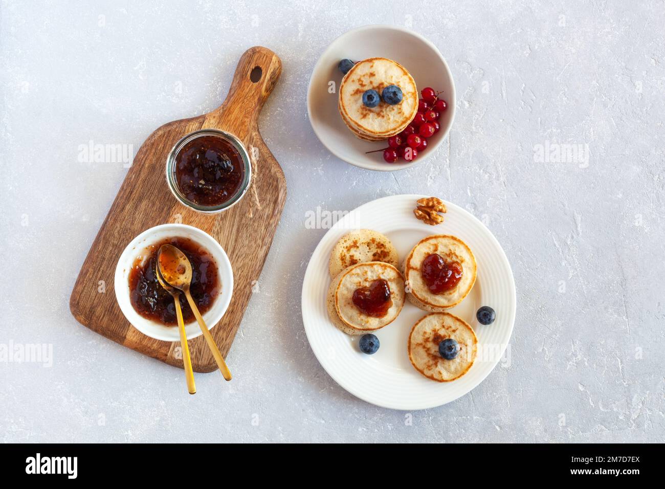 Petit déjeuner de la Saint-Valentin avec mini crêpes décorées de confiture en forme de coeur et de baies fraîches, vue de dessus Banque D'Images