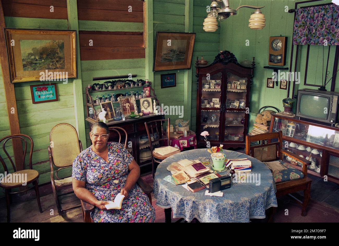 Surinam, femme âgée est assise dans son salon dans une maison en bois qui est typique pour l'architecture à Paramaribo et entre le style hollandais fureur Banque D'Images