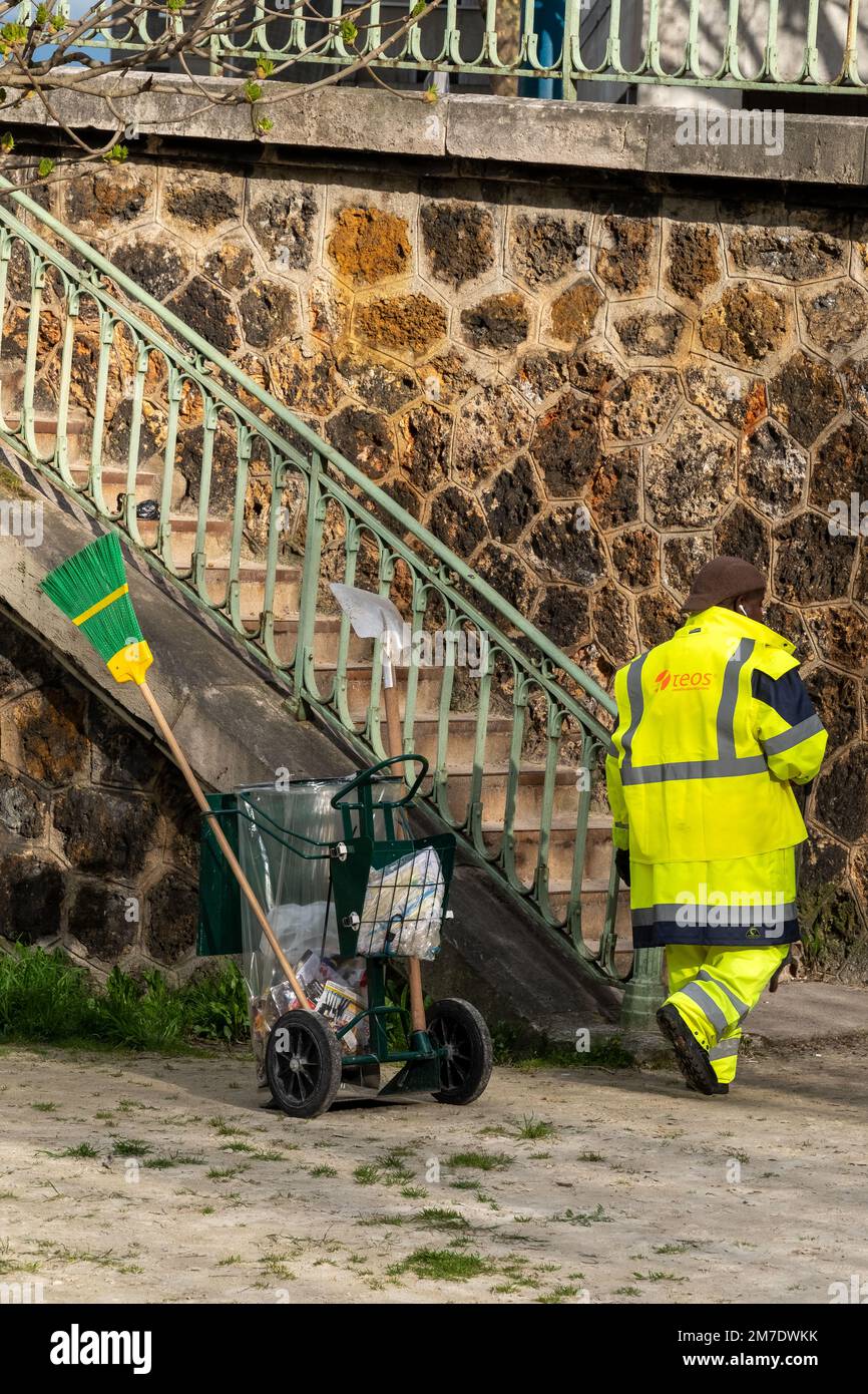Agent de nettoyage de rue vêtu de jaune dans un parc public Banque D'Images