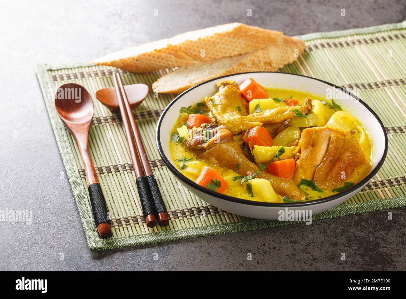 CA ri ga est un curry de poulet vietnamien délicieusement parfumé mais doux, imprégné d'herbes fraîches et d'épices dans une assiette sur la table. Horizontale Banque D'Images