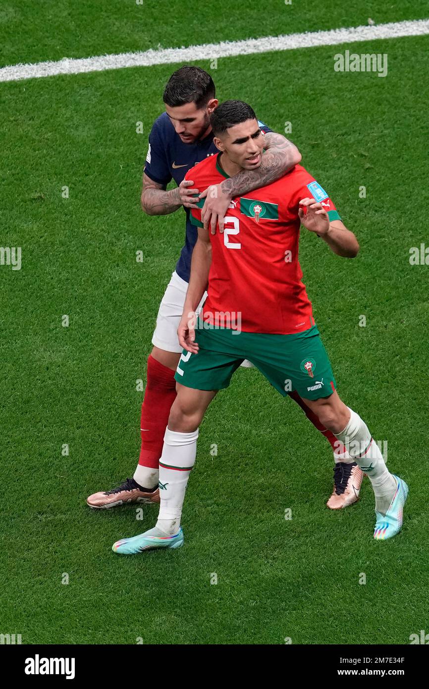 Morocco's Achraf Hakimi, right, gestures towards the referee as France's Theo Hernandez holds him during the World Cup semifinal soccer match between France and Morocco at the Al Bayt Stadium in Al Khor, Qatar, Wednesday, Dec. 14, 2022. (AP Photo/Thanassis Stavrakis) Banque D'Images