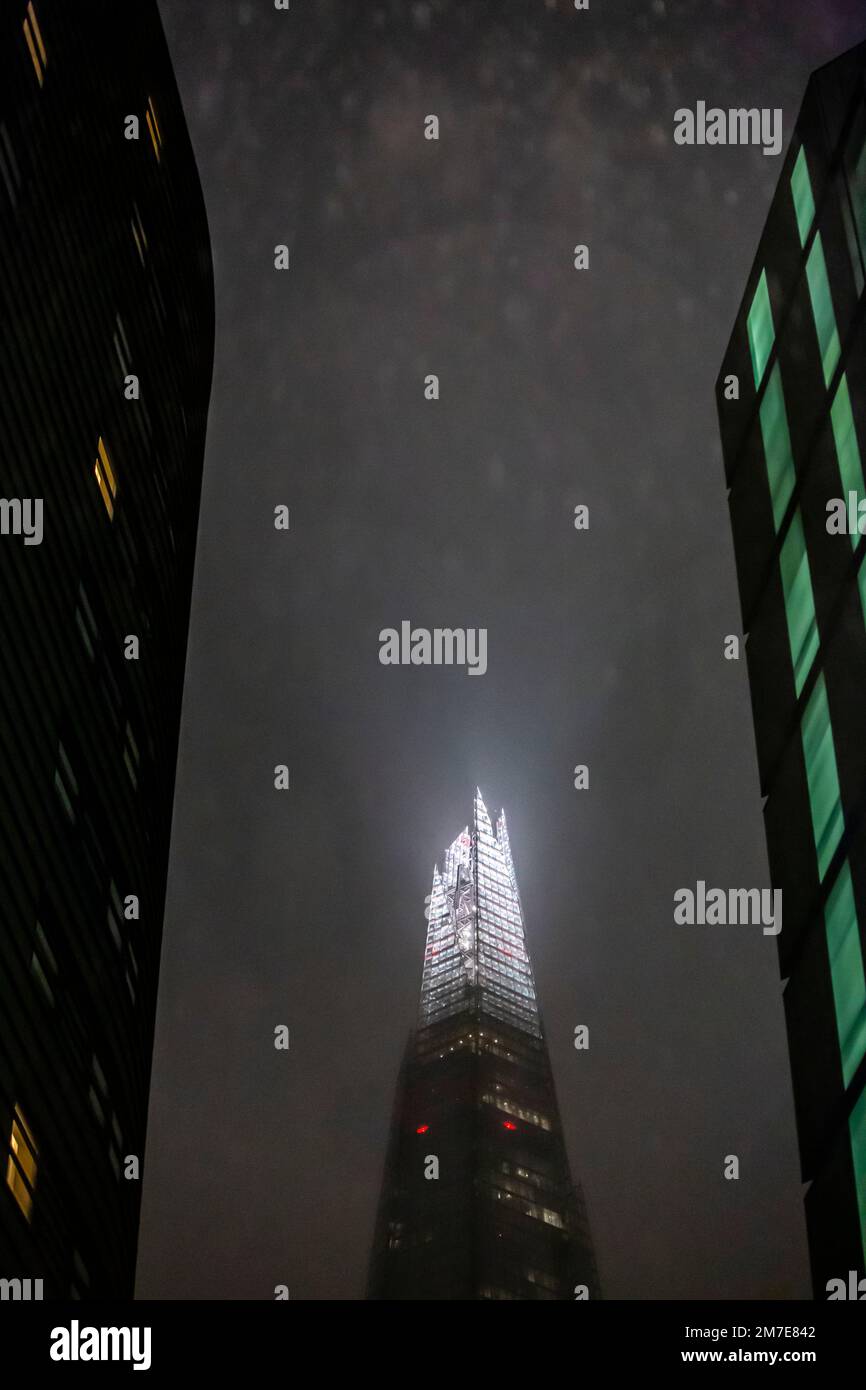 Vue sur le bâtiment Shard de londres la nuit avec de la bruine, de la brume et de la pluie obscurcissant la vue car il est entouré d'autres blocs de bureaux et de gratte-ciel. Banque D'Images