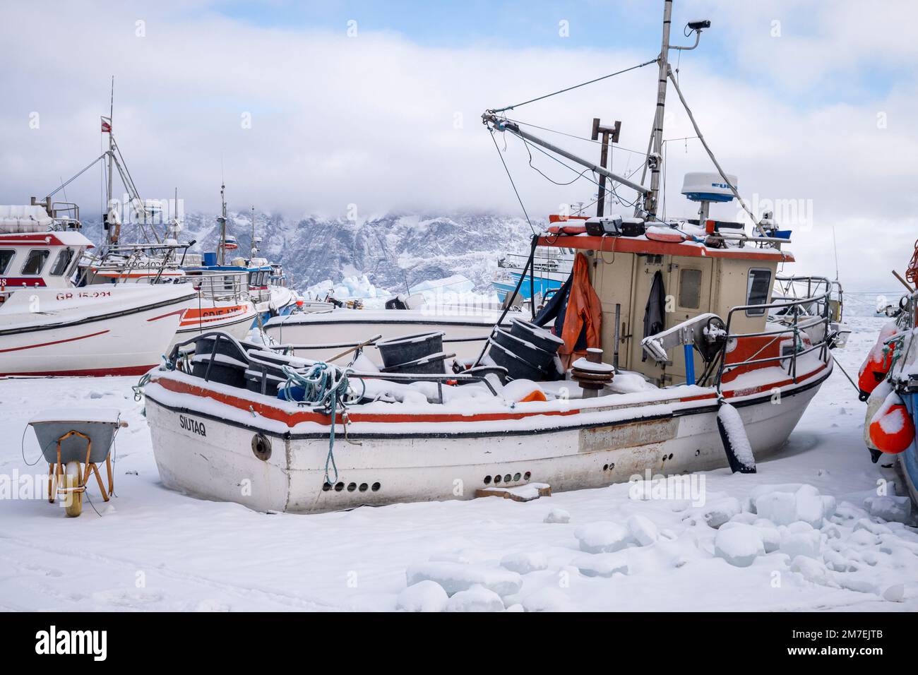 Bateaux de pêche gelés dans la glace de mer dans le port d'Uummannaq, dans l'ouest du Groenland Banque D'Images