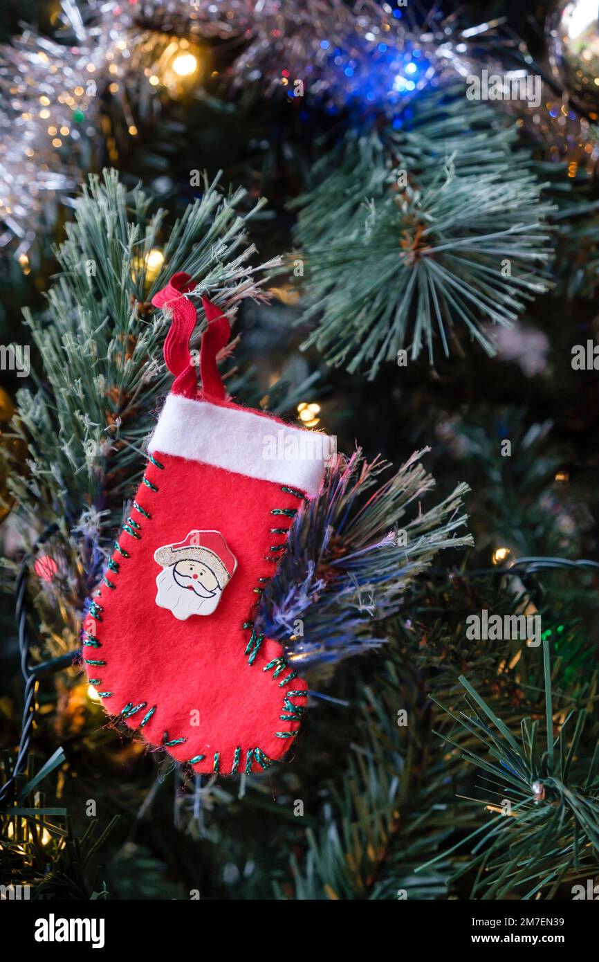 Une petite décoration de Noël accrochée à un sapin de Noël en forme de bas de Noël avec le visage de Père Noël. Banque D'Images