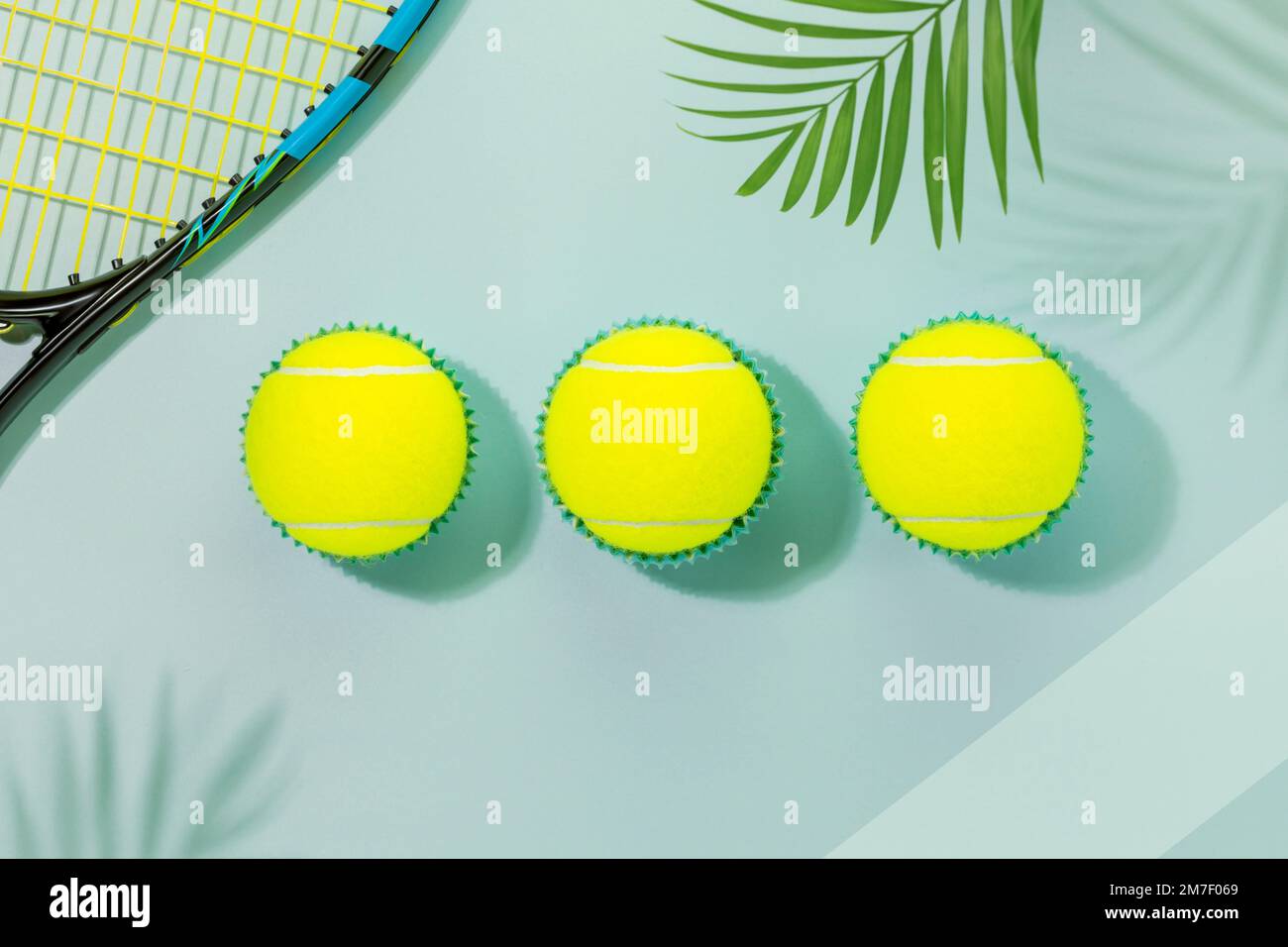 Carte de compétition de tennis. Composition sportive avec balles de tennis jaunes et raquette de tennis sur fond bleu avec feuilles de palmier et ombres. Sport a Banque D'Images
